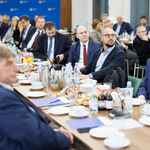Zdjęcie z posiedzenia, uczestnicy w tle.