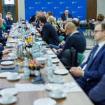Zdjęcie z posiedzenia, uczestnicy w tle.