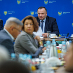 Zdjęcie z posiedzenia, uczestnicy w tle.