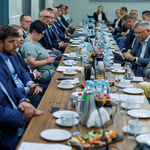 Zdjęcie z posiedzenia, uczestnicy w tle.