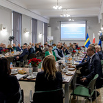 Ujęcie sali z uczestnikami, w tle slajd prezentacji.