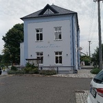 Zdjęcie budynku firmy Nobilis Tilia w kolorze błękitnym, widoczony jest parking przed budynkiem