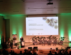 Na zdjęciu Marszałek Województwa Śląskiego Leszek Pietraszek otwiera II Śląskie Forum Sprawiedliwej Transformacji. Widoczny jest ekran ze slajdem informującym, że organizatorem II Śląskiego Forum Sprawiedliwej Transformacji jest Departament Rozwoju i Transformacji Regionu Urzędu Marszałkowskiego Województwa Śląskiego. Na scenie są fotele dla panelistów, małe stoliczki, w tle - baner Regionalnego Obserwatorium Procesu Transformacji oraz kwiaty doniczkowe.