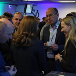 Na zdjęciu znajdują się stojący w grupkach uczestnicy konferencji podczas przerwy.