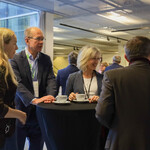 Na zdjęciu widać stojących w grupie uczestników konferencji podczas przerwy.