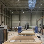 Wnętrze nowoczesnej hali produkcyjnej z automatyczną linią do prefabrykacji drewnianych elementów ściennych i konstrukcyjnych.
